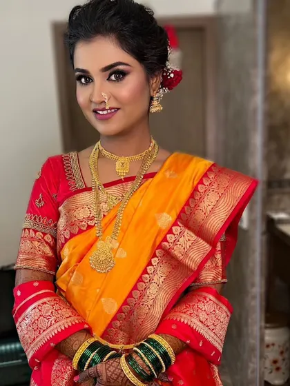 The full look of the beautiful Maharashtrian bride. Her makeup is fresh and radiant, complementing the vibrant colors of her Paithani saree and traditional gold jewelry.