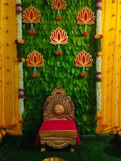 A full and centered view of the half saree function stage, showing the beautiful symmetry of the betel leaf wall and the surrounding floral decorations.