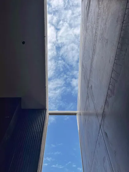 A shot looking up at the sky through a gap in the structure during construction. We always look for opportunities like this to create moments of connection with the outside, framing the sky and bringing in light.