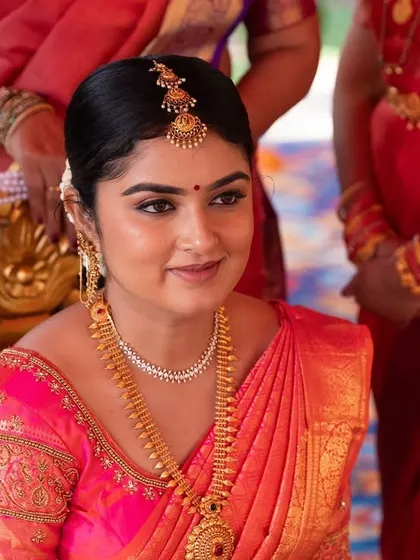 Shubha looking radiant during her wedding ceremony. The makeup gives her a warm, golden glow that matches her beautiful saree.