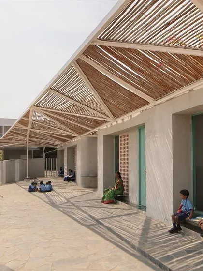 Children playing and learning in the shaded corridor of a new pavilion at the Talaricheruvu Rural School. The design provides a variety of spaces for both formal and informal activities.