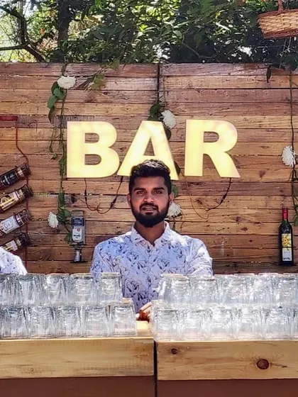 A member of our team ready for service at a rustic-themed wedding bar. We ensure our staff are always friendly, approachable, and ready to make your guests feel welcome.