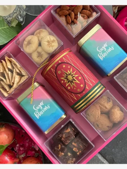 This is my Bomb Tray, a truly grand gesture for Diwali gifting. It is loaded with a curated selection of gourmet treats like brownie bites, mini chocolate chip cookies, peri peri almonds, and other festive sweets, all arranged beautifully on a reusable tray.