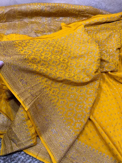 Check the complete look of this vibrant yellow Banarasi silk saree. The pallu and border are heavily woven with intricate patterns in antique gold zari.