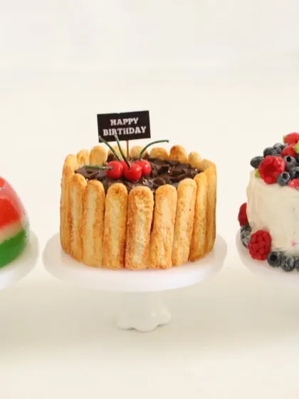 A collection of three miniature cakes: watermelon jelly, chocolate truffle, and a berry chantilly cake.