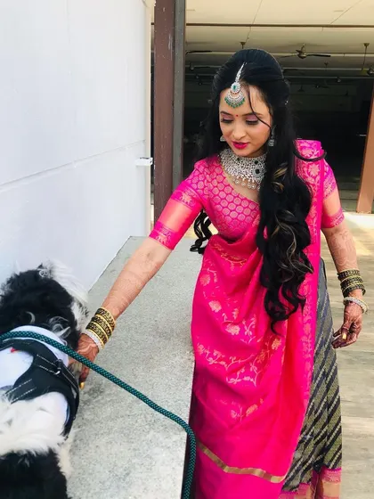 The bride taking her furry friend for a walk before the event. Her makeup is fresh and ready for the day's festivities.