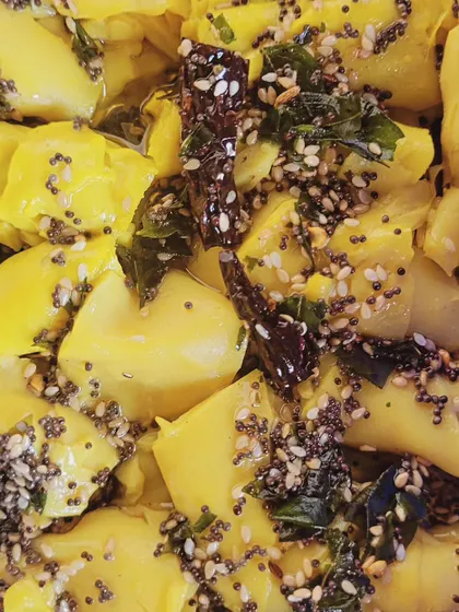 This extreme close-up shows the texture and tempering of my Khandvi, another popular Gujarati snack I offer. It's made from gram flour and seasoned with mustard and sesame seeds.