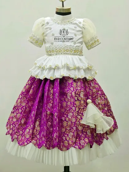 Another beautiful Banarasi lehenga set for sisters. The white top with puff sleeves is paired with a purple brocade skirt, featuring a double-layered design for extra volume and flair.