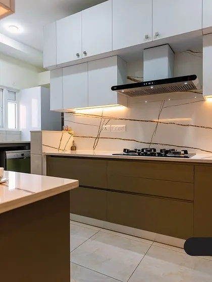 This earthy mocha kitchen features two-toned cabinetry, with rich brown lower cabinets and white uppers. The dramatic veining of the quartz countertop and backsplash adds a luxurious touch.