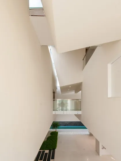the resulting interior volume… a tall, narrow space within the neeti residence, drawing light down from skylights.