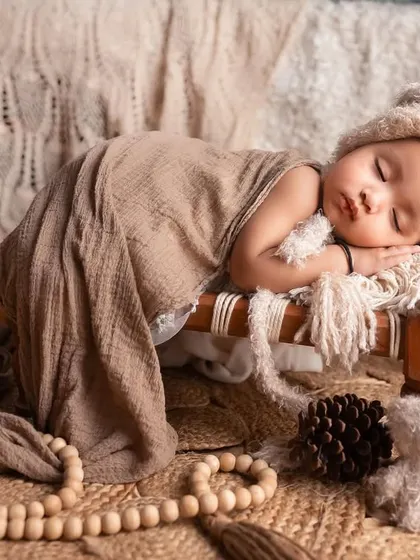 Another angle of this sleeping angel. The soft, neutral-toned fabrics and the tiny teddy bear create a very serene and heartwarming newborn-style portrait.