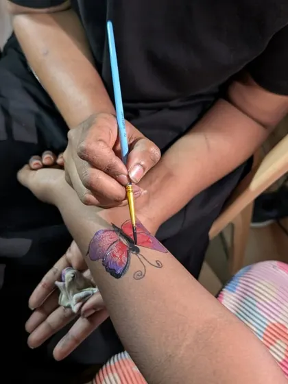 We love making our adoption drives fun for the whole family. Here, a young visitor gets a beautiful butterfly painted on her arm at our paint tattoo station at the Lawrence High School event.