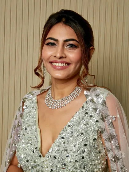 You can never have too much shimmer. This client is glowing in a full-glam look with silver glitter eyeshadow, radiant skin, and a chic ponytail for her reception.