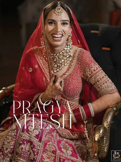 A radiant bride smiling, captured in her beautiful red and gold wedding lehenga.