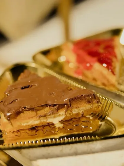 A classic dessert duo: freshly made waffles topped with decadent chocolate sauce and a sweet strawberry drizzle. It's a comforting and indulgent treat for guests of all ages.