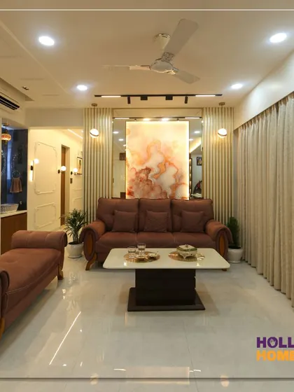 A wide view of the living and dining area, showing how we integrated a comfortable lounge space with a chaise, a modern sofa set, and a dedicated wash basin area with decorative niches.