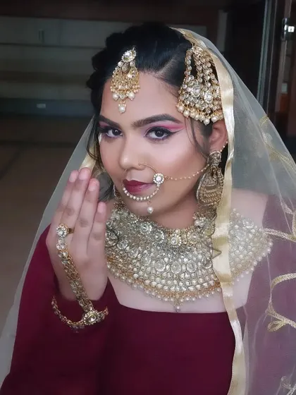 A classic 'salaam' pose from our Muslim bride, showcasing the full effect of the makeup, 'passa' (head jewelry), and 'nath' (nose ring).