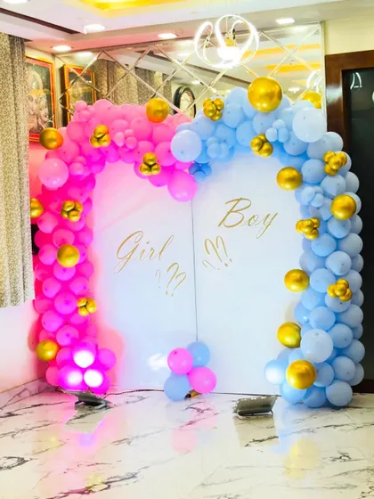 A different angle of the pink and blue gender reveal backdrop, showing the lighting on the balloons.