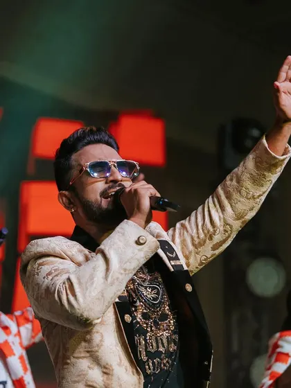 A live band performance at a grand Sangeet, with the lead singer engaging the crowd and creating an electric atmosphere.