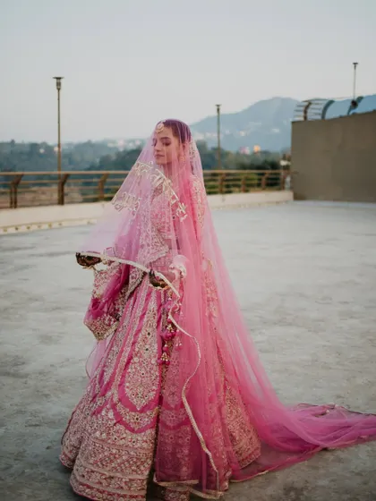 The bride's entry is a moment of pure grace and anticipation. Here, the long veil and the mountain backdrop create a breathtakingly beautiful and serene bridal portrait, capturing her elegance as she walks towards her future.