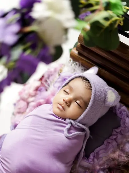 An overhead shot showing the baby nestled in a basket of flowers. This angle highlights how small and precious they are, creating a beautiful keepsake.