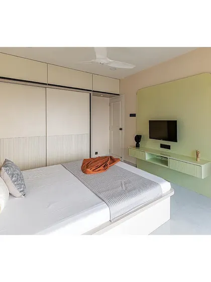 Another angle of the master bedroom, highlighting the seamless integration of the wardrobe and TV unit. The light color palette makes the room feel spacious and tranquil.