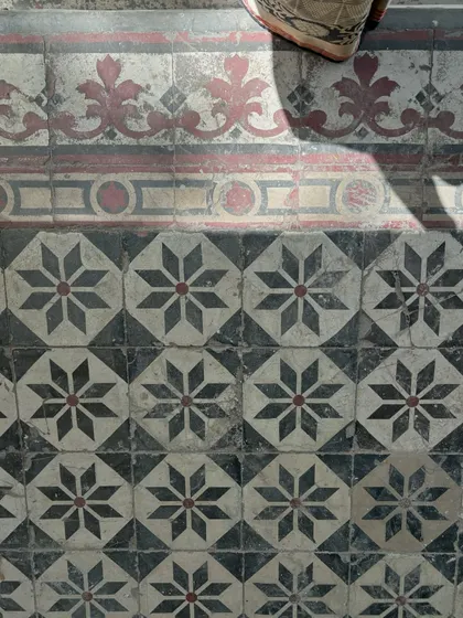 The soul of a building is in its details. We painstakingly preserve and restore original features like these beautiful geometric floor tiles in a classic Delhi house. This commitment to craftsmanship ensures the building's story and character endure.