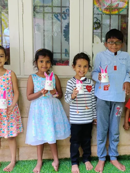 A group of happy campers holding up the bunny cup crafts they made. Group photos like this capture the sense of community and shared fun at our camp.