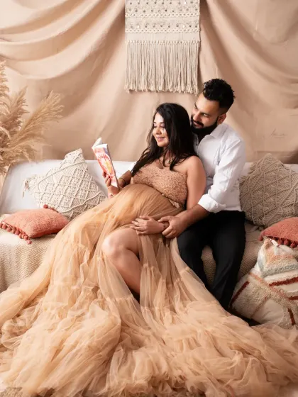 A cozy and intimate moment on our studio's boho-style setup. Reading a book to the baby bump is a sweet way to capture your growing bond.