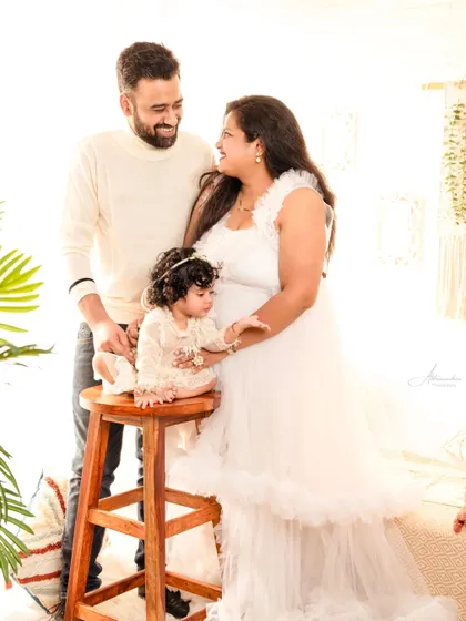 A full family portrait celebrating their daughter's first birthday, all dressed in elegant white.