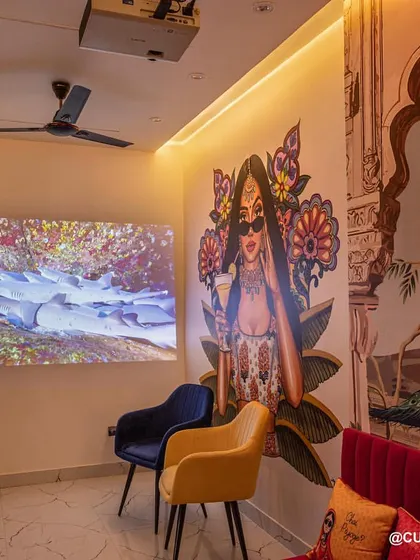 This family lounge doubles as a home theater. A projector is installed on the ceiling, turning the main wall into a large screen for an immersive movie-watching experience.