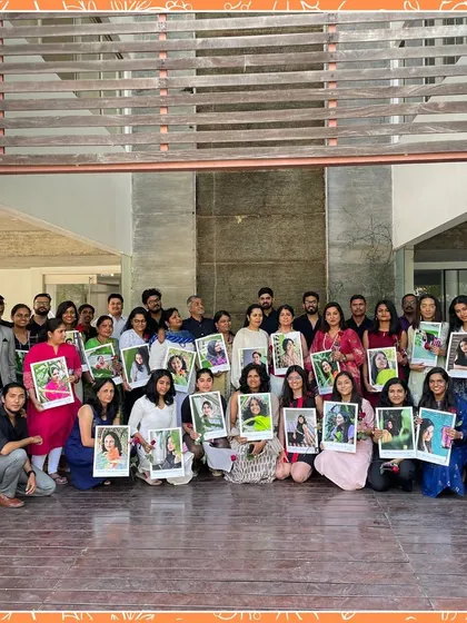 The GNA team celebrating their founder, Gayathri Shetty, holding up portraits of her.