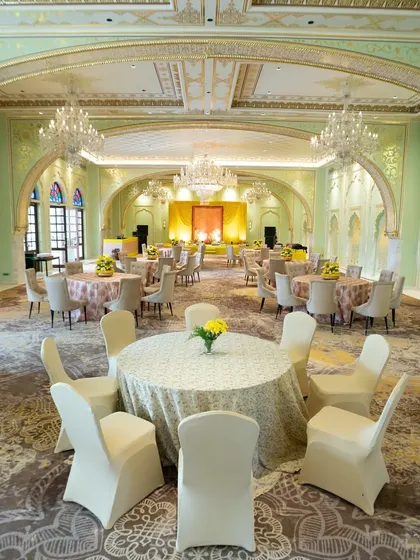 An elegant, pastel green ballroom at the Fairmont Jaipur, with classic European-style architecture and simple, refined table settings.