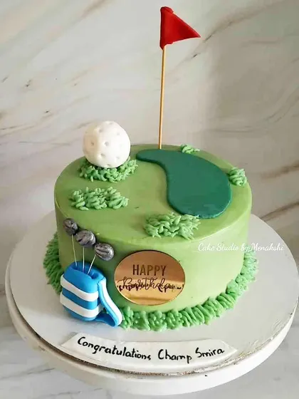 A golf themed birthday cake for a champ. The design features a green, a flag, a golf ball, and a bag of clubs.