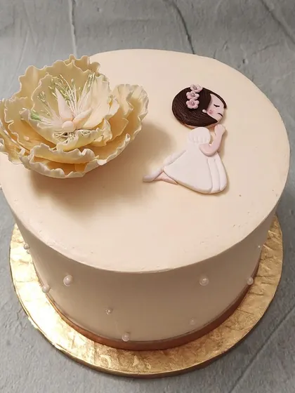 We craft a simple and spiritual cake for a Holy Communion. This design features a beautifully crafted sugar flower beside a praying girl figure, offering a moment of quiet reflection and grace for this important religious ceremony.