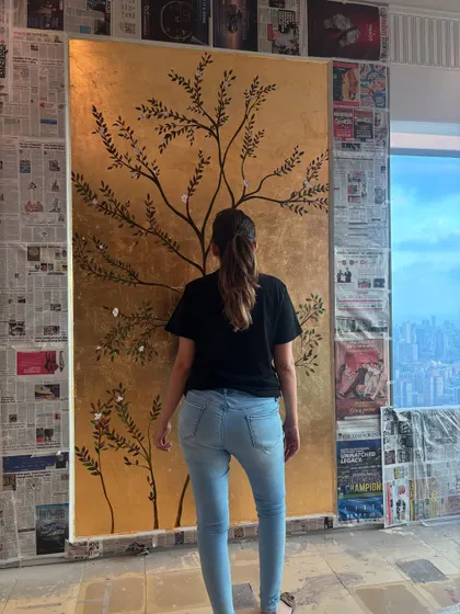 A view from the back, showing me admiring the nearly completed mural against the stunning city skyline. It's moments like these that make all the hard work worth it.