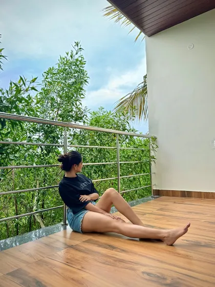 A guest enjoying the peaceful view from the balcony of her hill view room. The lush greenery provides a perfect backdrop for relaxation.