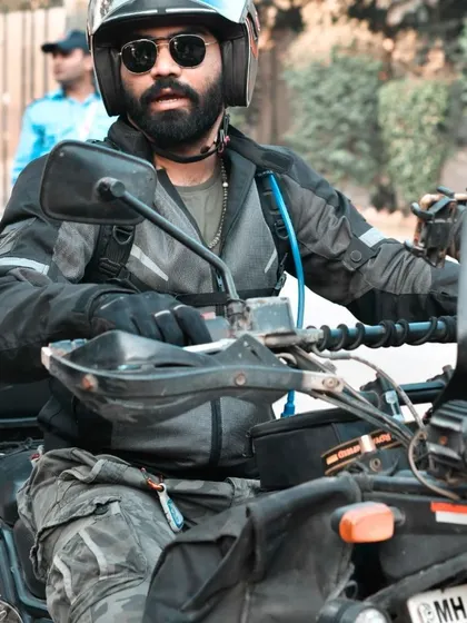 A rider on his Royal Enfield Himalayan, ready for the road. This action shot captures the adventurous spirit of touring and exploration central to the biker lifestyle.