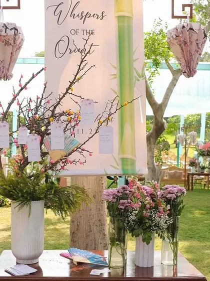 The guest seating chart for 'Whispers of the Orient', designed as a wishing tree with hanging tags. The setup was framed with custom-made paper lanterns and floral arrangements.