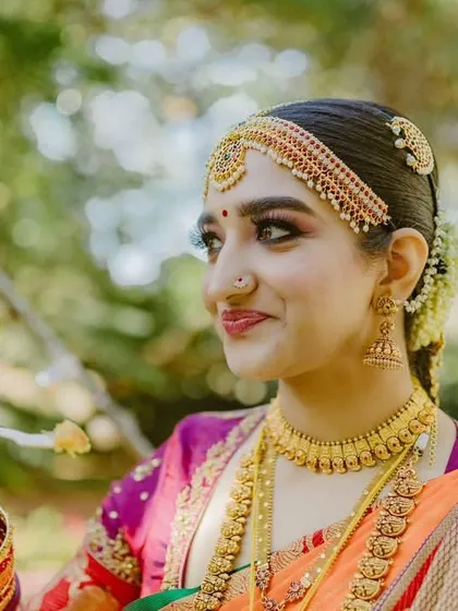 The beauty of a woman is in her eyes. Our bride Arpitha looks absolutely captivating in her orange and magenta Kanjeevaram saree, paired with a custom embroidered blouse for her wedding day.