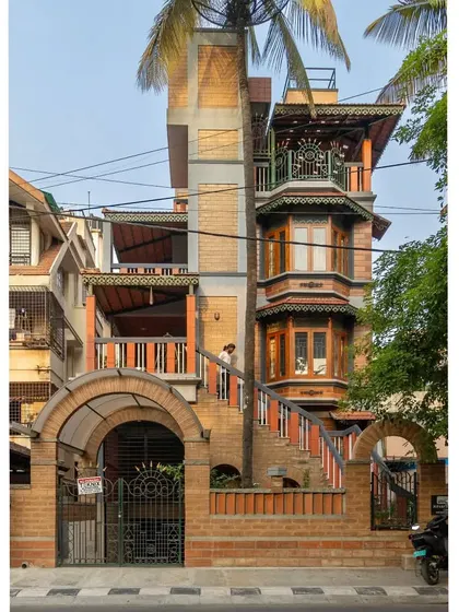 This home in Basavanagudi, Bangalore, is a testament to our belief in complex, layered design that feels organic and rooted. We integrated exposed earth blocks, traditional bay windows, and multiple balconies, even allowing a palm tree to grow through the structure, truly merging the building with its landscape.
