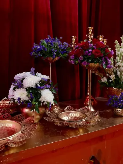 A detail shot of the floral arrangements on one of the console tables. I used a mix of white, purple, and red flowers in ornate copper and brass bowls and vases.