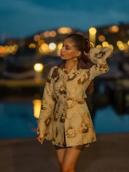 A full shot of the outfit against the beautiful backdrop of the Cannes marina at night.