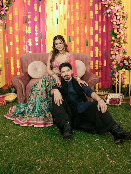 A stylish portrait of the couple, showcasing their stunning Sangeet outfits and relaxed confidence.