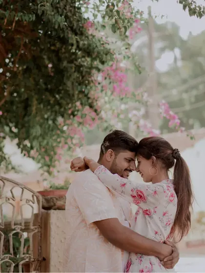An intimate embrace under a canopy of bougainvillea. The natural framing and soft light make this a very romantic portrait.