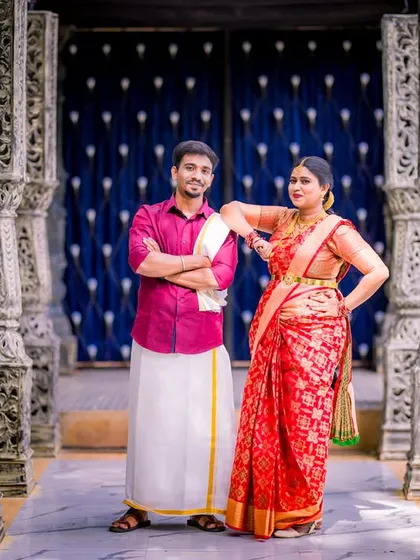 A confident and stylish pose by a couple in traditional South Indian attire. The ornate pillars create a powerful, symmetrical frame for this modern portrait.