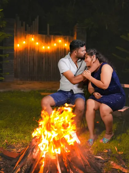 A tender moment by the bonfire, perfect for a romantic pre-wedding collection. The warm lighting highlights the couple's connection.