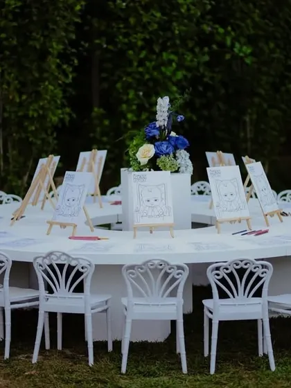 A fun painting station for the kids at the Boss Baby party, with easels and coloring pages set up on a large round table.