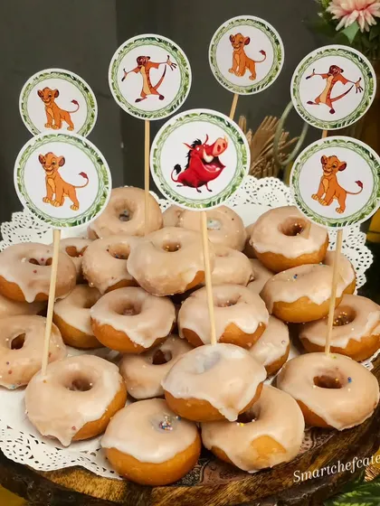 A tower of sugar-glazed donuts adorned with Lion King character toppers. It's a simple way to make a classic dessert fit perfectly into the party's theme.