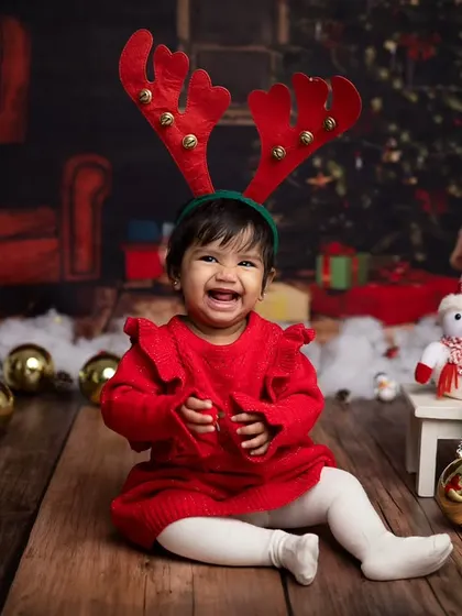 The reindeer antlers are on and she's all smiles! This is pure holiday cheer.